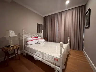 Cozy bedroom with elegant decor and natural light, featuring a classic bed and wooden flooring.