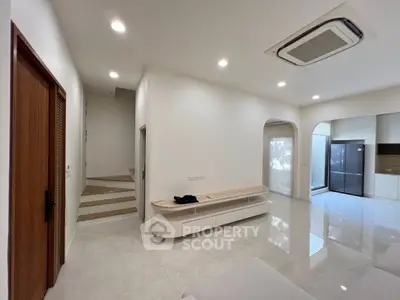 Spacious modern living area with sleek design and integrated kitchen appliances.