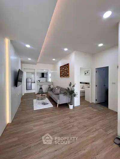 Modern open-plan living room with stylish decor and wooden flooring