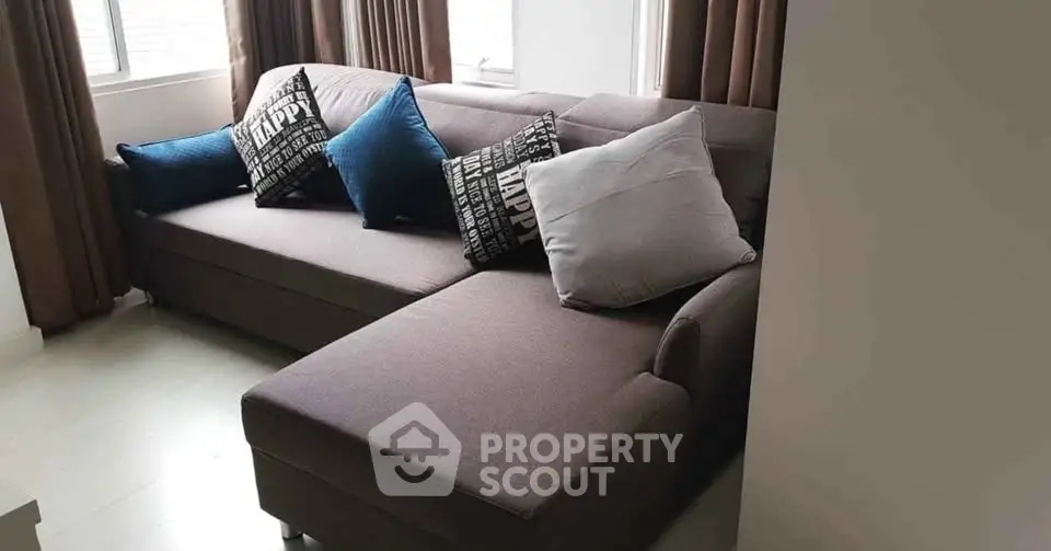 Modern living room with stylish sectional sofa and decorative pillows, perfect for cozy relaxation.