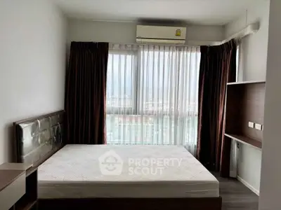 Modern bedroom with large window and air conditioning in urban apartment.