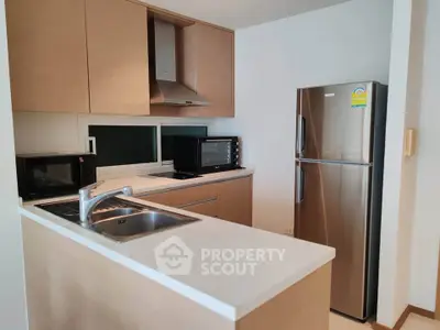 Modern kitchen with stainless steel appliances and sleek wooden cabinetry