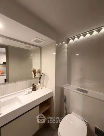 Modern bathroom with sleek fixtures and elegant lighting, featuring a stylish vanity and contemporary design.
