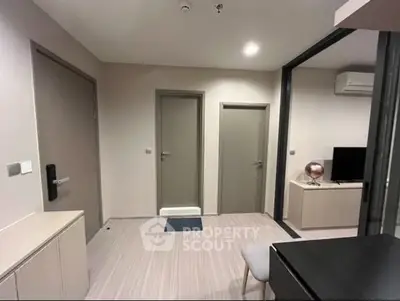 Modern interior with sleek design and neutral tones, featuring a compact living area with TV and air conditioning.