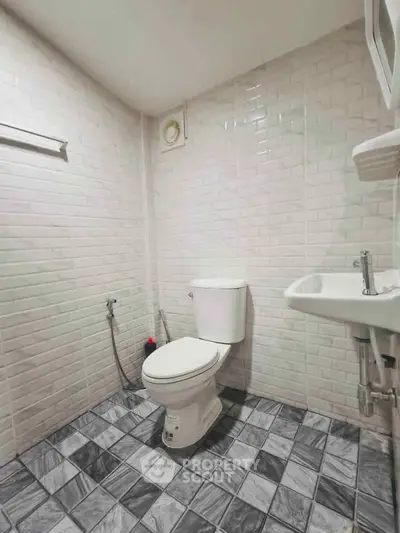 Modern bathroom with white brick tiles and checkered floor design
