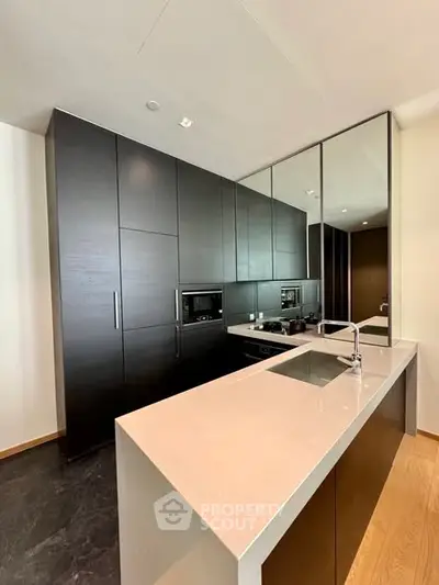 Modern kitchen with sleek black cabinets and integrated appliances