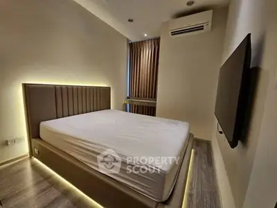 Modern bedroom with sleek design, featuring ambient lighting and wall-mounted TV for ultimate comfort.