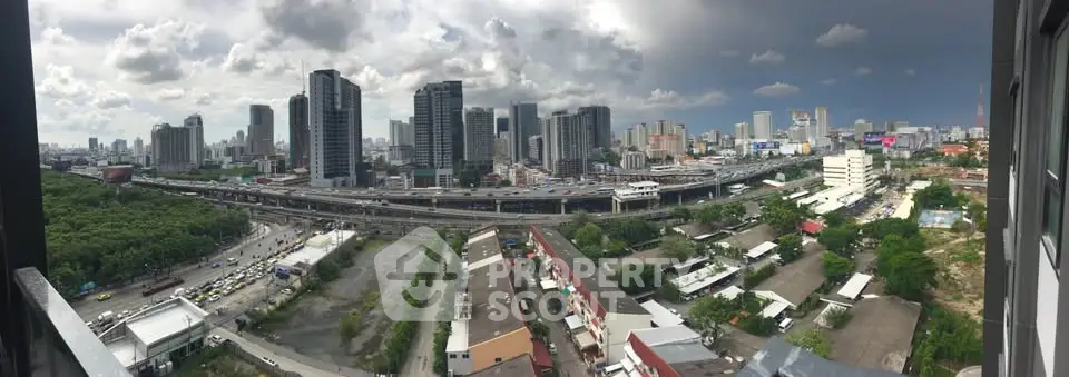 Panoramic cityscape view from high-rise building showcasing urban skyline and green spaces.