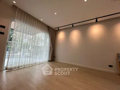 Spacious empty living room with large windows and elegant lighting