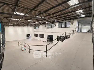 Spacious industrial warehouse with high ceilings and ample natural light.
