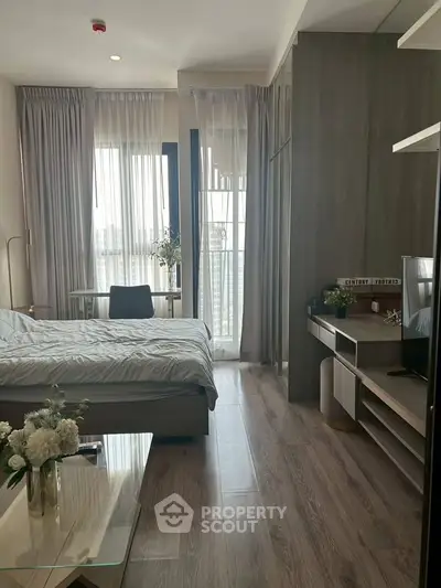 Modern bedroom with large windows and stylish decor in a high-rise apartment.