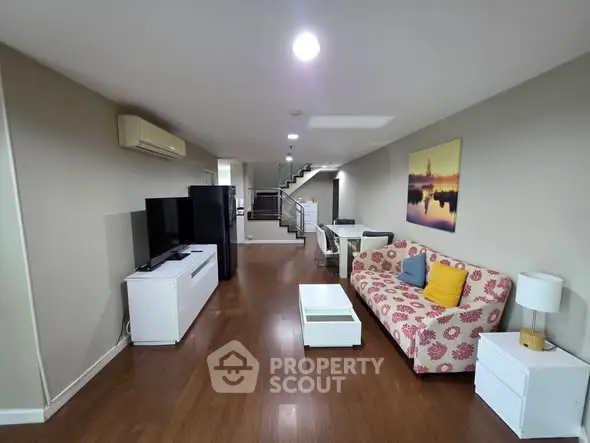 Spacious living room with modern decor and open layout, featuring a stylish sofa and entertainment center.