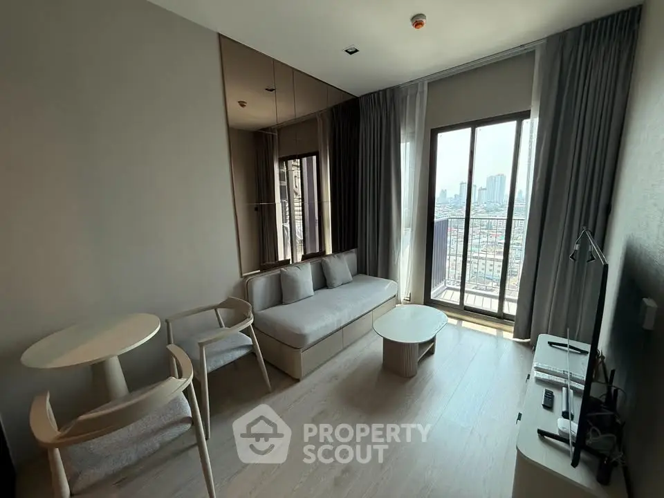 Modern living room with city view, featuring sleek furniture and floor-to-ceiling windows.