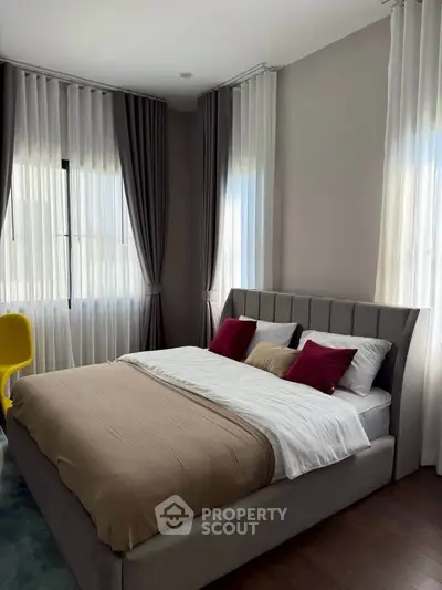 Modern bedroom with elegant curtains and stylish bed in a cozy setting.