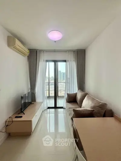 Modern living room with city view, cozy sofa, and sleek TV setup in a bright apartment.