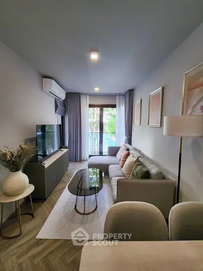 Modern living room with stylish decor, cozy seating, and natural light from large windows.