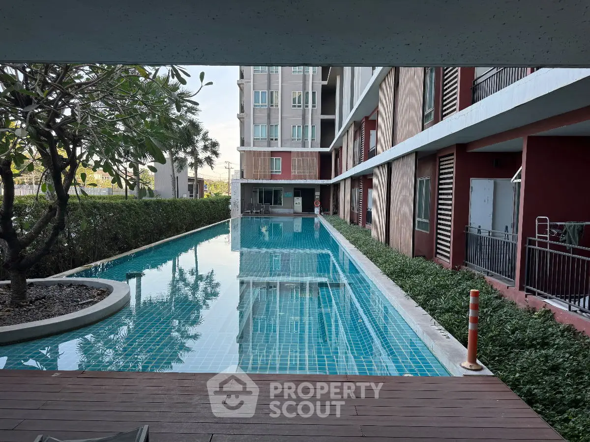 Modern condominium with sleek pool and lush greenery, perfect for relaxation and leisure.