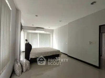 Spacious minimalist bedroom with large windows and modern decor