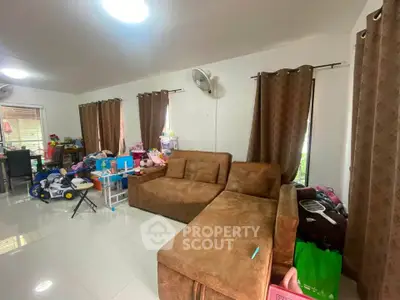 Spacious living room with modern brown sectional sofa and large windows, perfect for family gatherings.