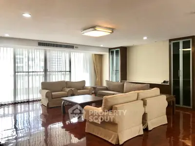 Spacious living room with elegant furniture and large windows offering natural light.