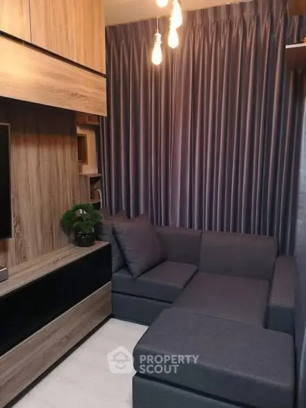 Cozy living room with modern gray sofa and elegant wooden cabinetry