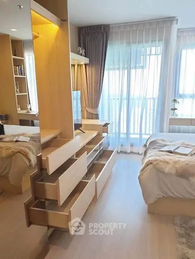 Modern bedroom with open drawers and large windows offering natural light and balcony access.