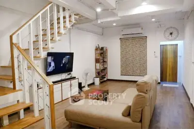 Charming living room with modern staircase and cozy seating area