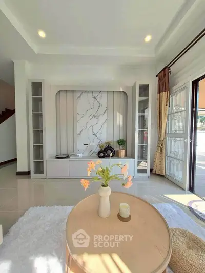 Elegant living room with modern decor and natural light, featuring a stylish marble accent wall.