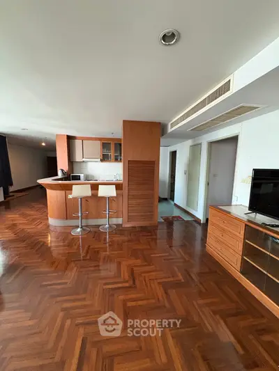 Spacious open-plan living area with modern kitchen and wooden flooring
