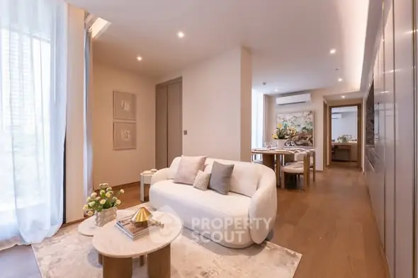 Luxurious modern living room with elegant decor and open dining area, featuring soft lighting and stylish furnishings.