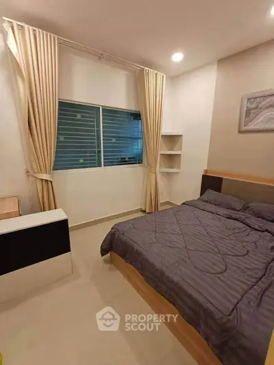 Cozy bedroom with modern decor and ample natural light.