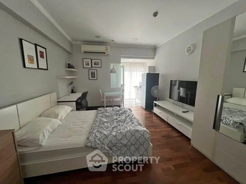 Modern studio apartment with cozy bedroom and living area, featuring stylish decor and natural light.