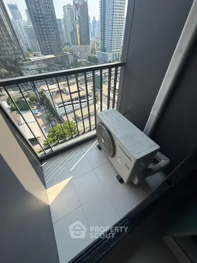 Compact balcony with city view and air conditioning unit in modern high-rise apartment.