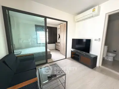 Modern living room with sleek furniture and view into a stylish bedroom