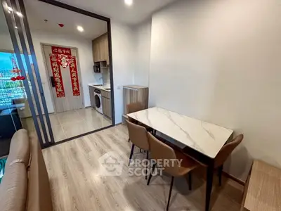 Modern dining area with marble table and kitchen view in stylish apartment