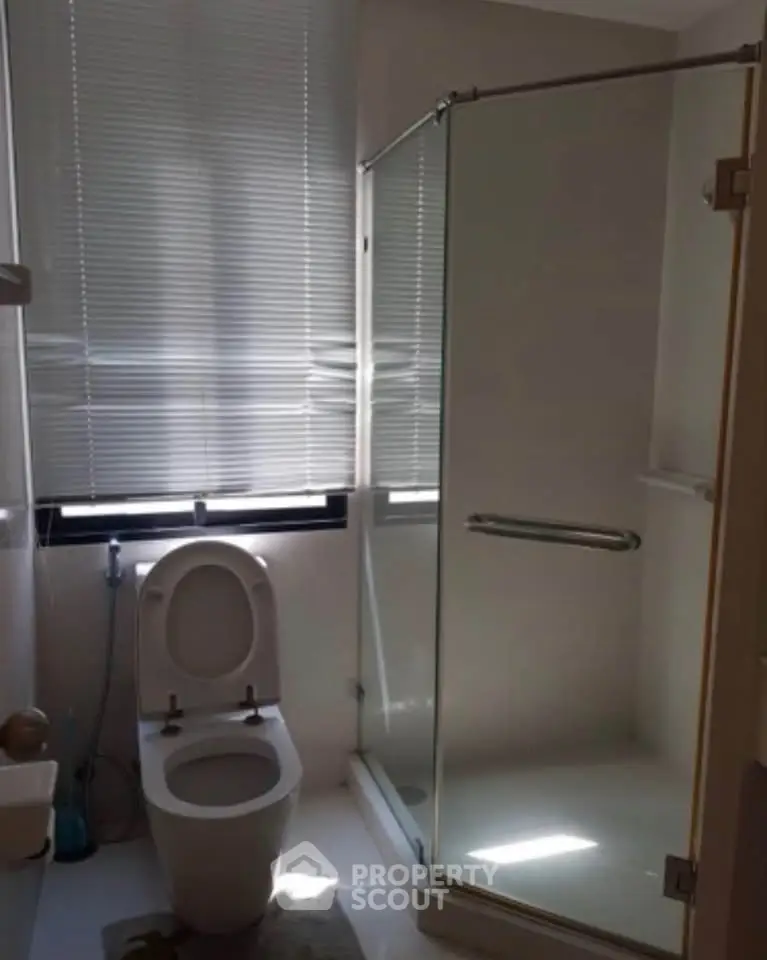 Modern bathroom with glass shower and window blinds