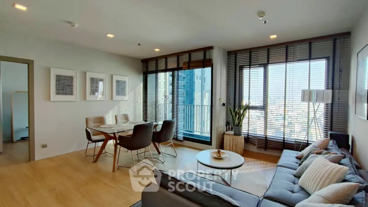 Modern living room with city view, stylish furniture, and natural light