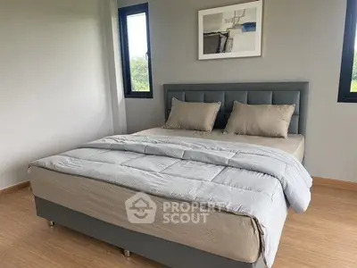 Modern bedroom with stylish decor and large windows offering natural light.