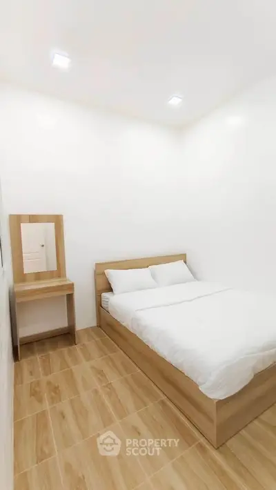 Cozy minimalist bedroom with wooden flooring and modern furniture
