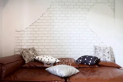 Stylish living room with leather seating and modern brick accent wall.