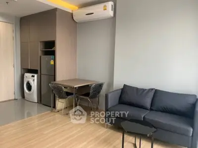 Modern living room with compact kitchen and washing machine, ideal for urban living.