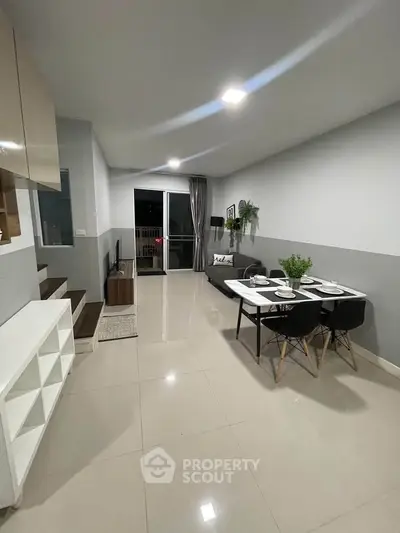 Modern living room with sleek dining area and balcony access, perfect for urban living.