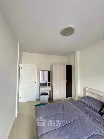 Spacious bedroom with modern wardrobe and cozy bedding in a minimalist design.