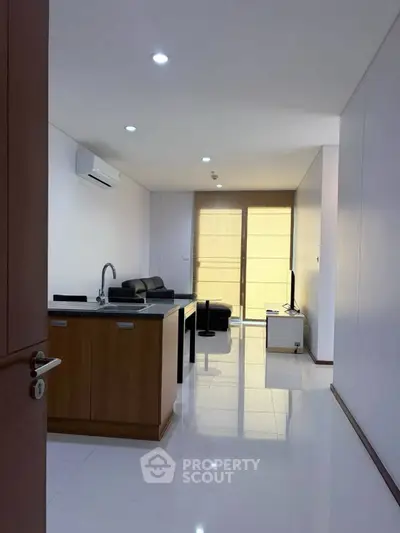 Modern open-plan living room with sleek kitchen island and cozy seating area, perfect for urban living.
