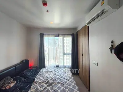 Cozy bedroom with city view, modern decor, and air conditioning in a high-rise apartment.