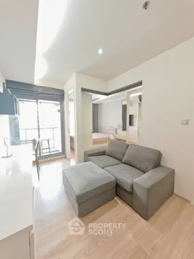 Modern living room with cozy gray sofa and natural light from balcony