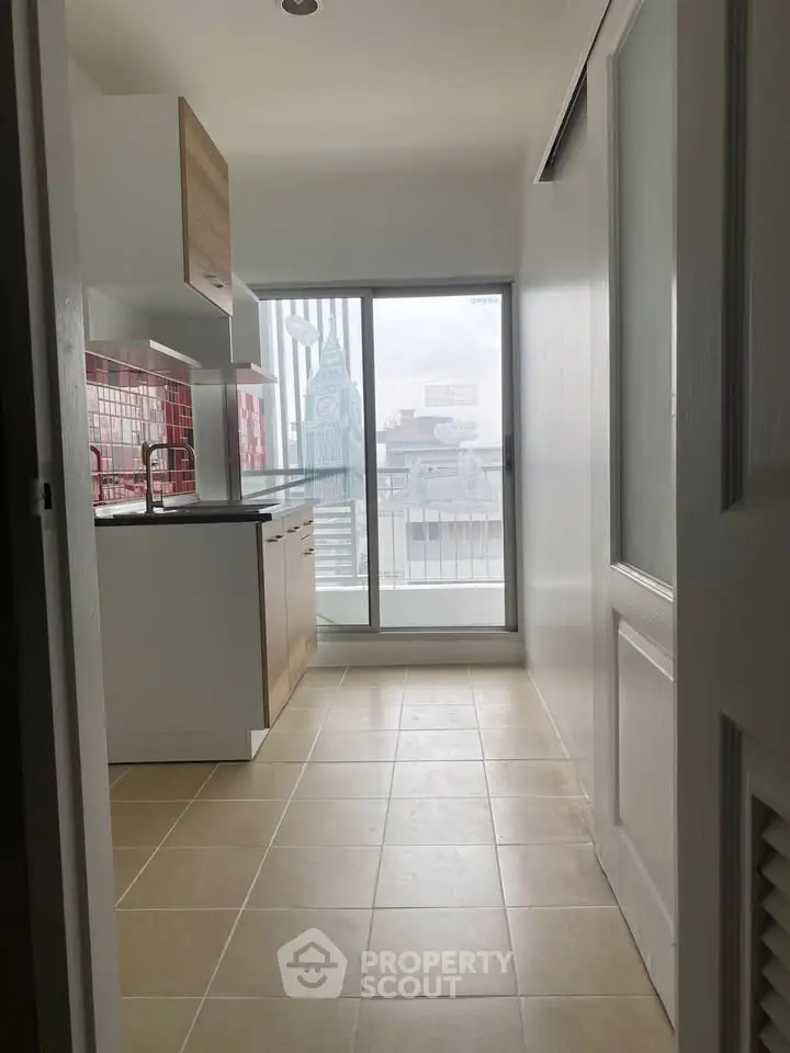 Modern kitchen with red backsplash and balcony view, perfect for urban living.