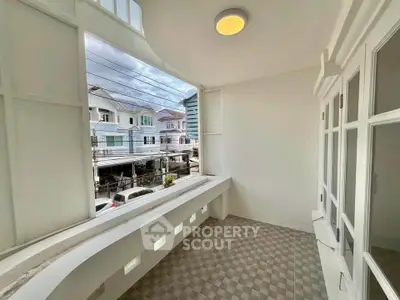 Charming balcony with tiled floor and street view in a residential neighborhood.