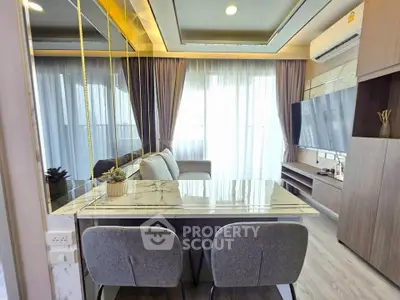 Modern living room with elegant decor and large TV, featuring a stylish marble dining table.