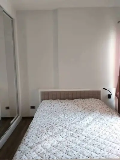 Cozy bedroom with mirrored closet and soft lighting, perfect for relaxation.